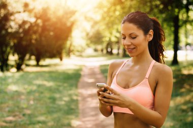 Telefon kullanan sportif kadın