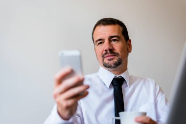 cep telefonu kullanan olgun bir adam