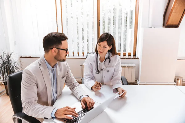 Patient consulting with doctor in hospital