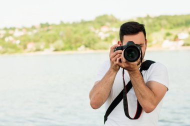 DSLR fotoğraf makinesi tutan adam.