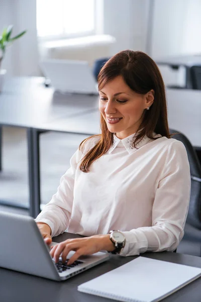 Mujer en la oficina trabajando con el ordenador portátil —  Fotos de Stock