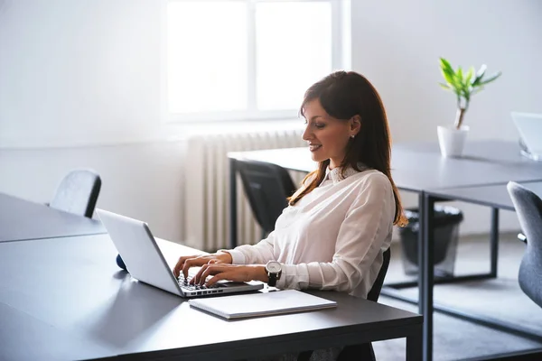 Kvinna på kontoret arbetar med bärbar dator — Stockfoto