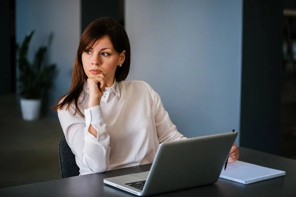 Mujer en la oficina trabajando con el ordenador portátil —  Fotos de Stock