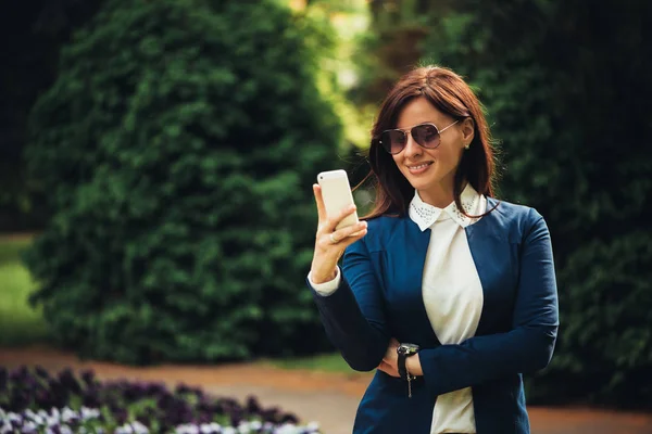 Empresária atraente usando smartphone — Fotografia de Stock