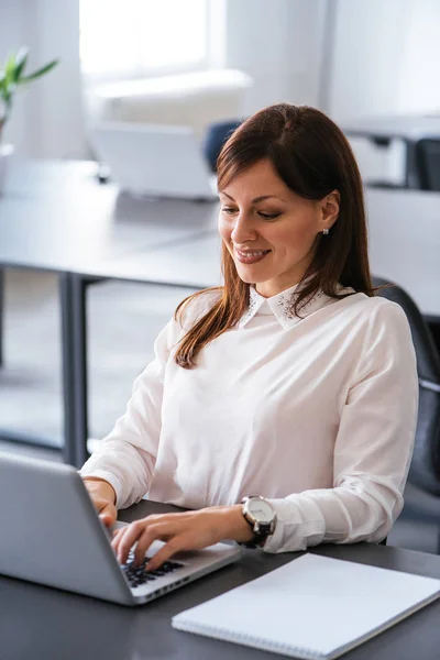 Mujer en la oficina trabajando con el ordenador portátil —  Fotos de Stock