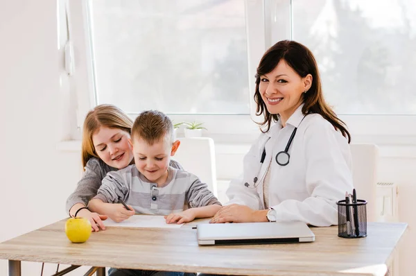 Läkare leker med barn i office — Stockfoto