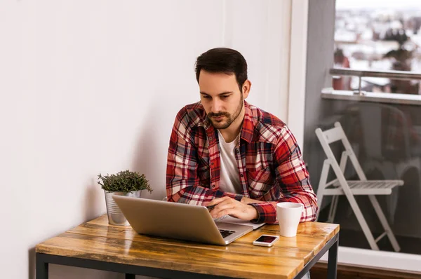 Hombre trabajando en el escritorio con el ordenador portátil . — Foto de Stock