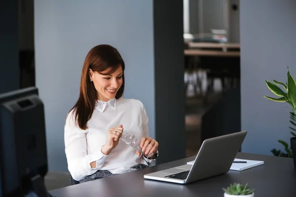 Affärskvinna dricksvatten i office. — Stockfoto