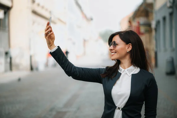 Kobieta za pomocą telefonów komórkowych na ulicy — Zdjęcie stockowe