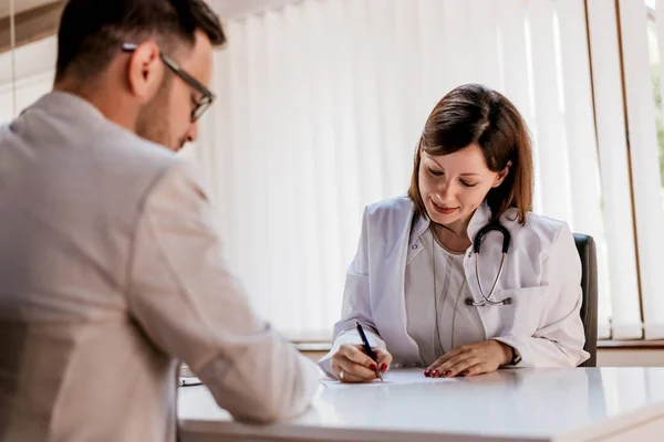 Médico escribir receta al paciente — Foto de Stock