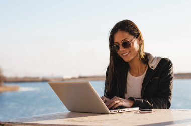 Laptop ile çalışan güneş gözlüklü kız 