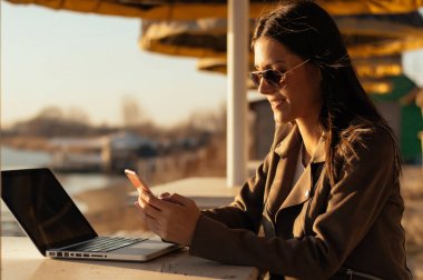 Dizüstü bilgisayar kullanarak güneş gözlüğü gülümseyen kız