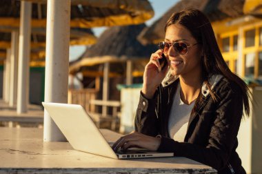 Dizüstü bilgisayar kullanarak güneş gözlüğü gülümseyen kız