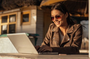 Laptop ile çalışan güneş gözlüklü kız 