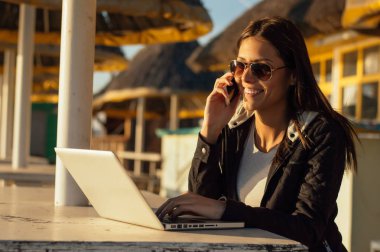 Dizüstü bilgisayar kullanarak güneş gözlüğü gülümseyen kız