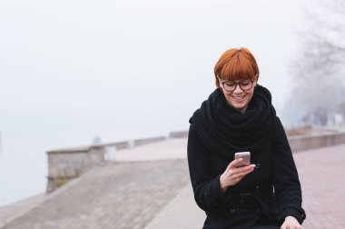 Akıllı telefon kullanan gülümseyen kadın. 