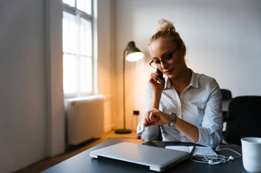 Ofiste telefonla konuşan bir kadın.