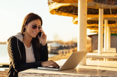 Laptop ile çalışan güneş gözlüklü kız 