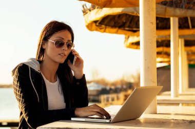 Laptop ile çalışan güneş gözlüklü kız 