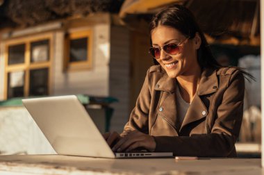 Laptop ile çalışan güneş gözlüklü kız 