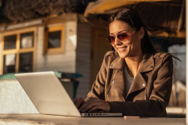 Laptop ile çalışan güneş gözlüklü kız 