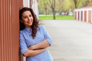 Kıvırcık kız duvara sonraki ayakta 