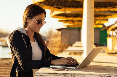 Laptop ile çalışan güneş gözlüklü kız 