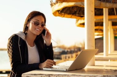 Laptop ile çalışan güneş gözlüklü kız 