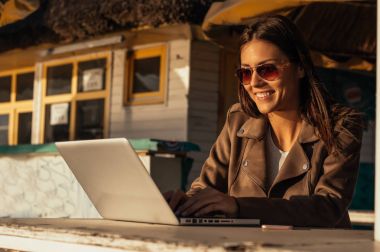 Laptop ile çalışan güneş gözlüklü kız 