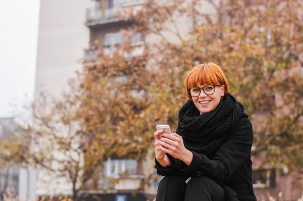 Усміхнена жінка використовує смартфон — стокове фото