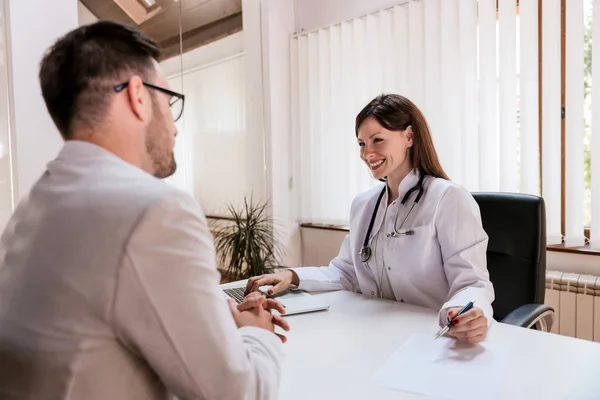 Médico reportando paciente masculino — Foto de Stock