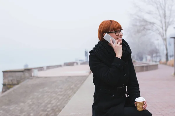 Молодая рыжая женщина разговаривает по телефону — стоковое фото