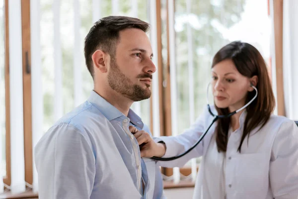 Doctor listening heartbeat of patient — Stock Photo, Image