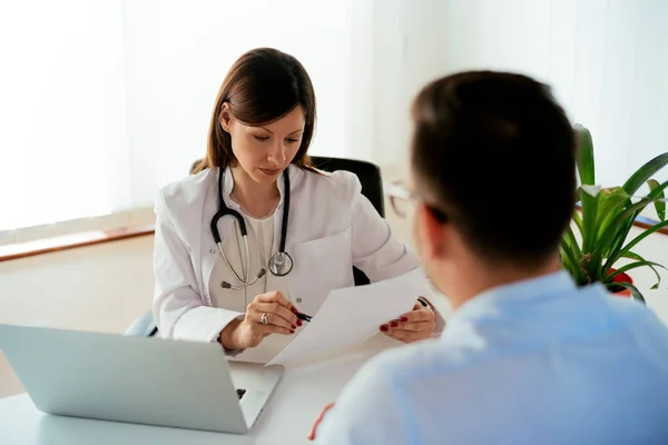 Médico reportando paciente masculino — Foto de Stock