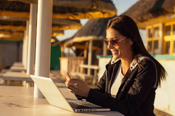 Dizüstü bilgisayar kullanarak güneş gözlüğü gülümseyen kız
