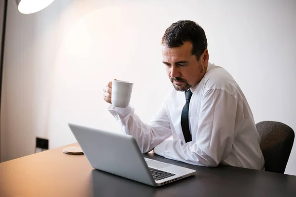 Empresario sentado junto al portátil —  Fotos de Stock