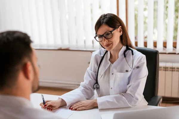 Dokter rapportage mannelijke patiënt — Stockfoto