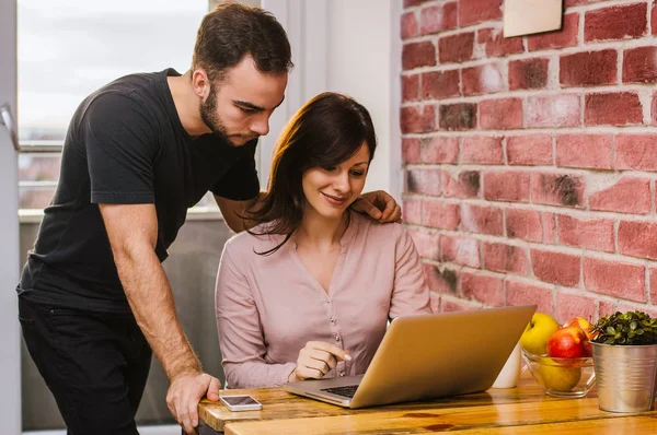 Pareja joven trabajando con portátil — Foto de Stock