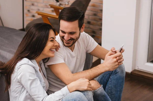 Pareja alegre viendo los medios — Foto de Stock