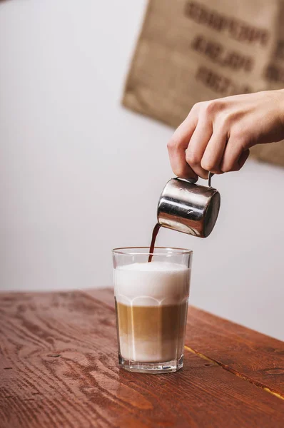barista pouring coffee in milk