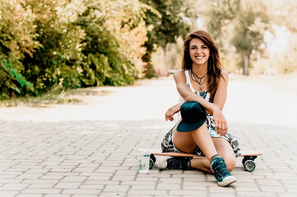 Frau sitzt über Skateboard — Stockfoto