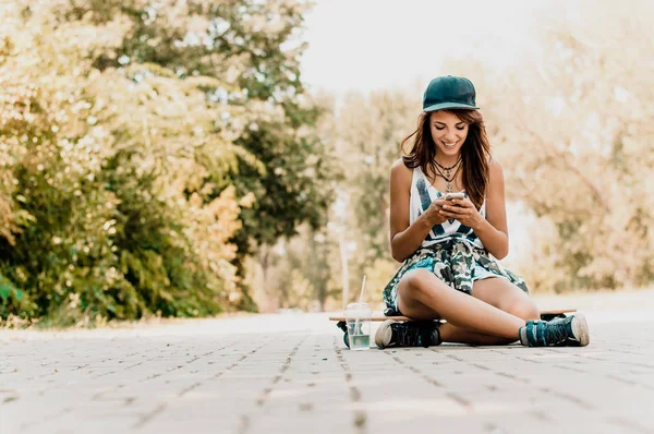 Mujer sentada sobre monopatín — Foto de Stock