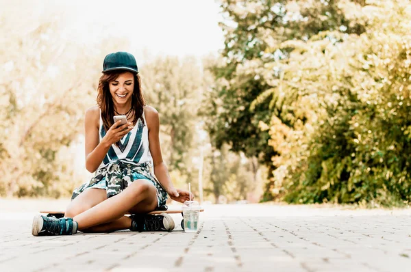 Mujer sentada sobre monopatín — Foto de Stock