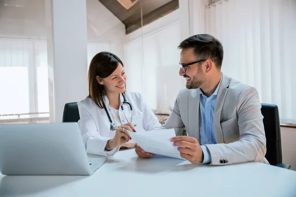 Médico reportando paciente masculino — Foto de Stock