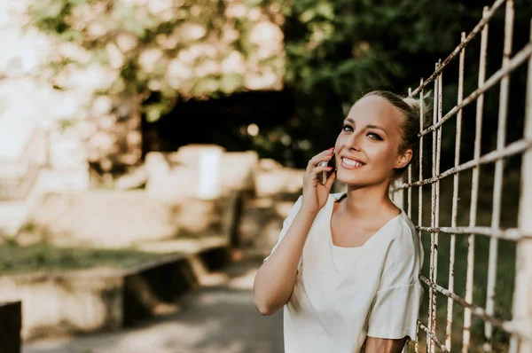 Mujer rubia sosteniendo smartphone — Foto de Stock