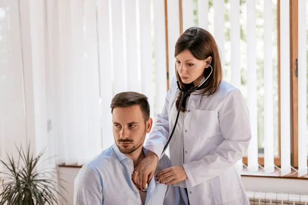 Medico ascolto battito cardiaco del paziente — Foto Stock