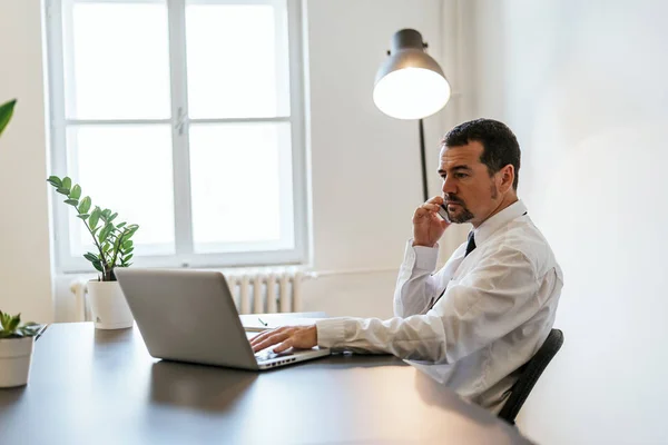 Reifer Geschäftsmann arbeitet am Laptop — Stockfoto