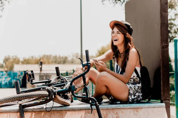 Mulher sentada ao lado da bicicleta — Fotografia de Stock