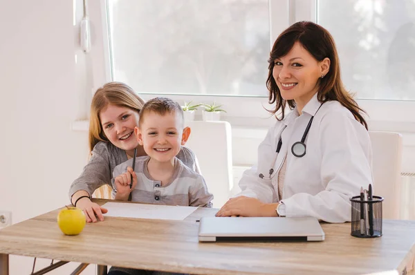Médico e crianças brincando na clínica — Fotografia de Stock