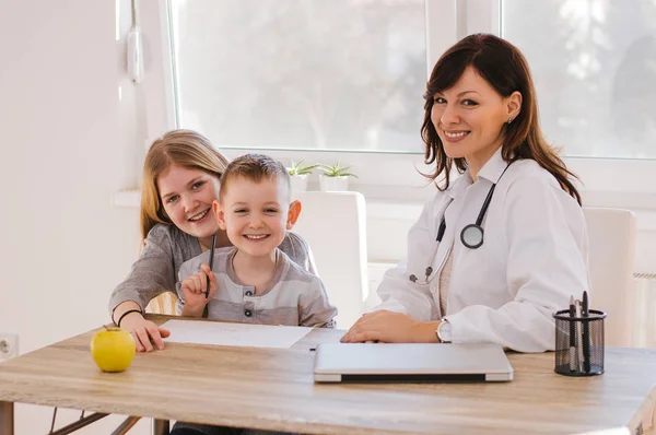 Läkare och barn som leker vid kliniken — Stockfoto